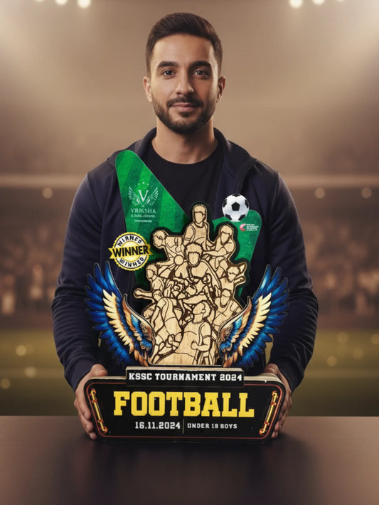 Man holding a football trophy with a blurred stadium background
