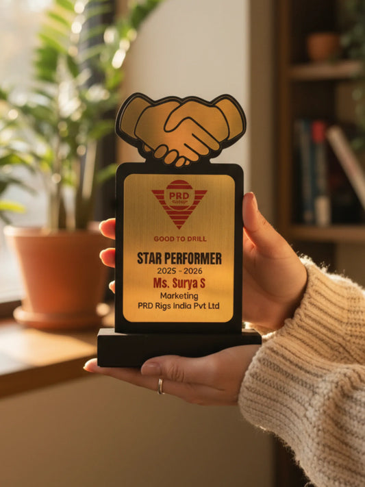 Hand holding a star performer award with a handshake design in an indoor setting.