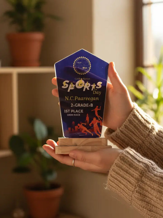 Person holding a sports day award in a home setting with plants in the background