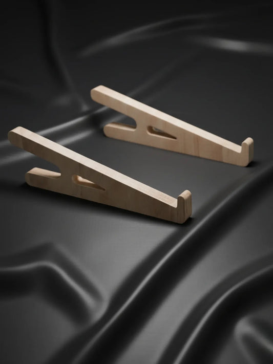 Two wooden car ramps on a black textured surface