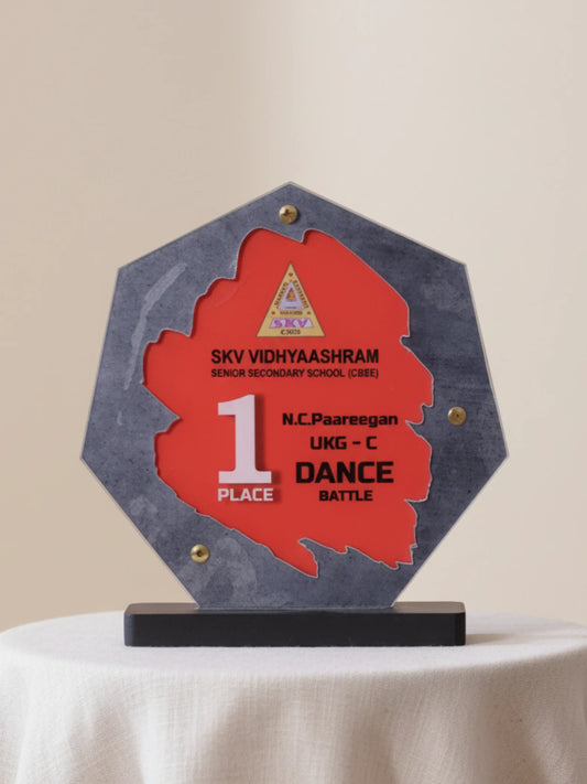 Hexagonal award with red center and gray base on a beige background