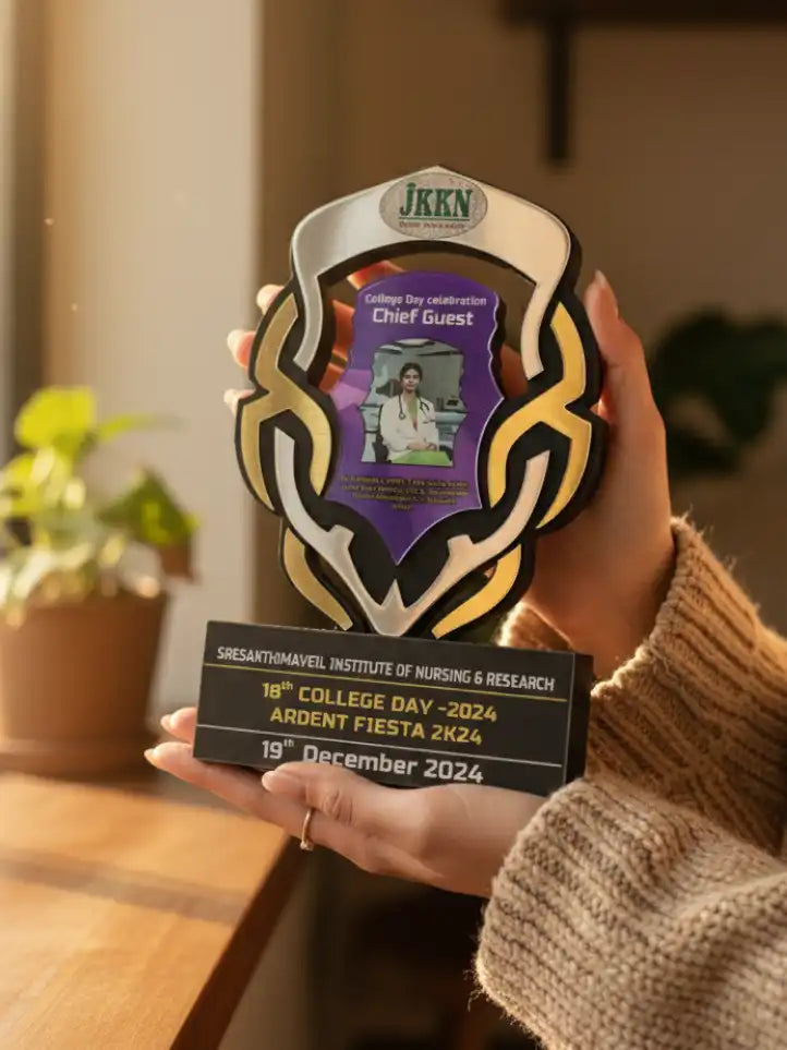 Person holding a decorative award with text and a photo on a blurred indoor background