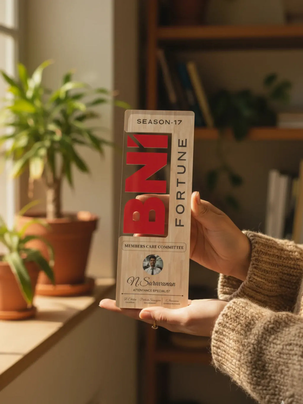 Person holding a box of Fortune cigarettes with plants and a bookshelf in the background