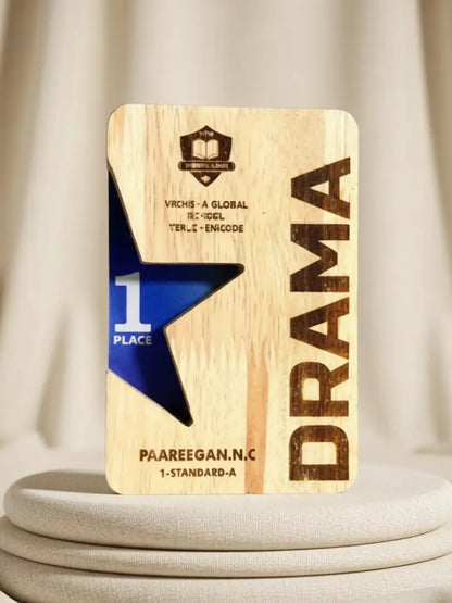 Wooden plaque with 'Drama' and '1 Place' text on a neutral background