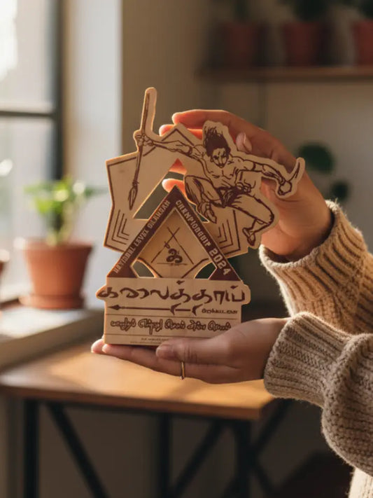 Person holding a wooden product with artistic design in a home setting