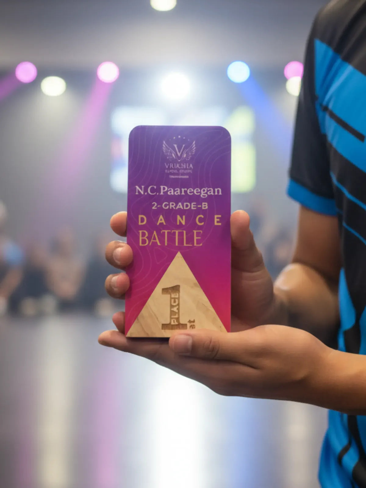 Hand holding a purple award with 'N.C. Paareegan Dance Battle' text against a blurred background