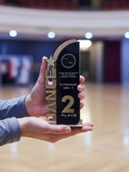 Person holding a trophy with '2nd Place' and 'N.C. Pareen' text in an indoor setting