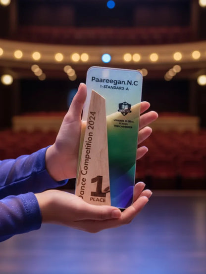 Hand holding a smartphone with a Paareegan.N.C award on a blurred theater stage background
