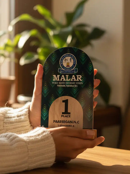 Person holding a Malar award with a plant in the background