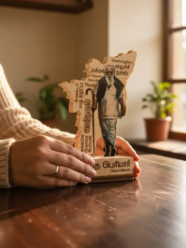 Person holding a wooden cutout of a man with text in a warm indoor setting