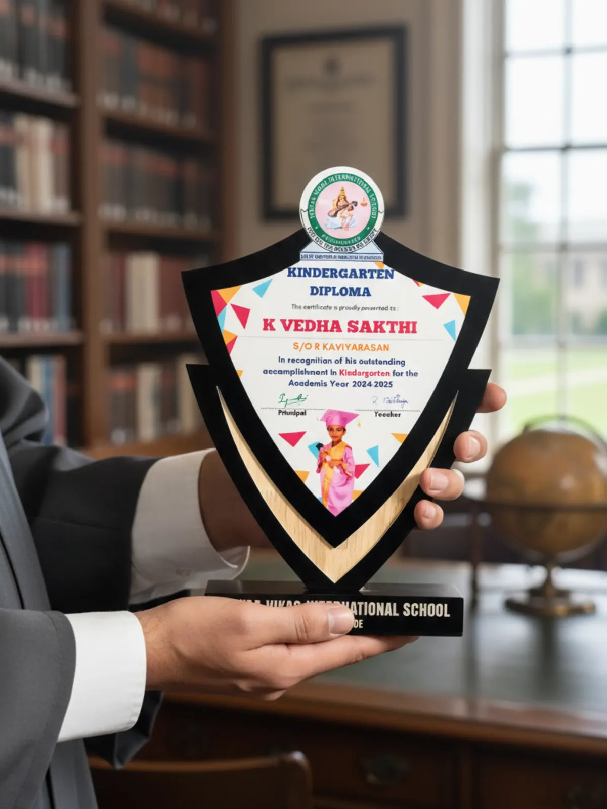 Person holding a kindergarten diploma with colorful design in an office setting