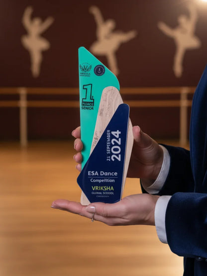 Person holding a decorative award with 'ESA Dance Competition' text in a dance studio setting