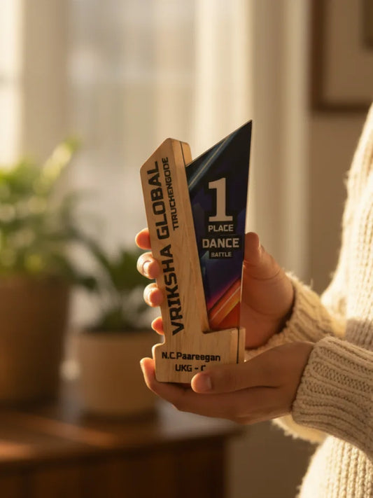 Hand holding a wooden trophy with 'Vriksha Global' branding indoors.