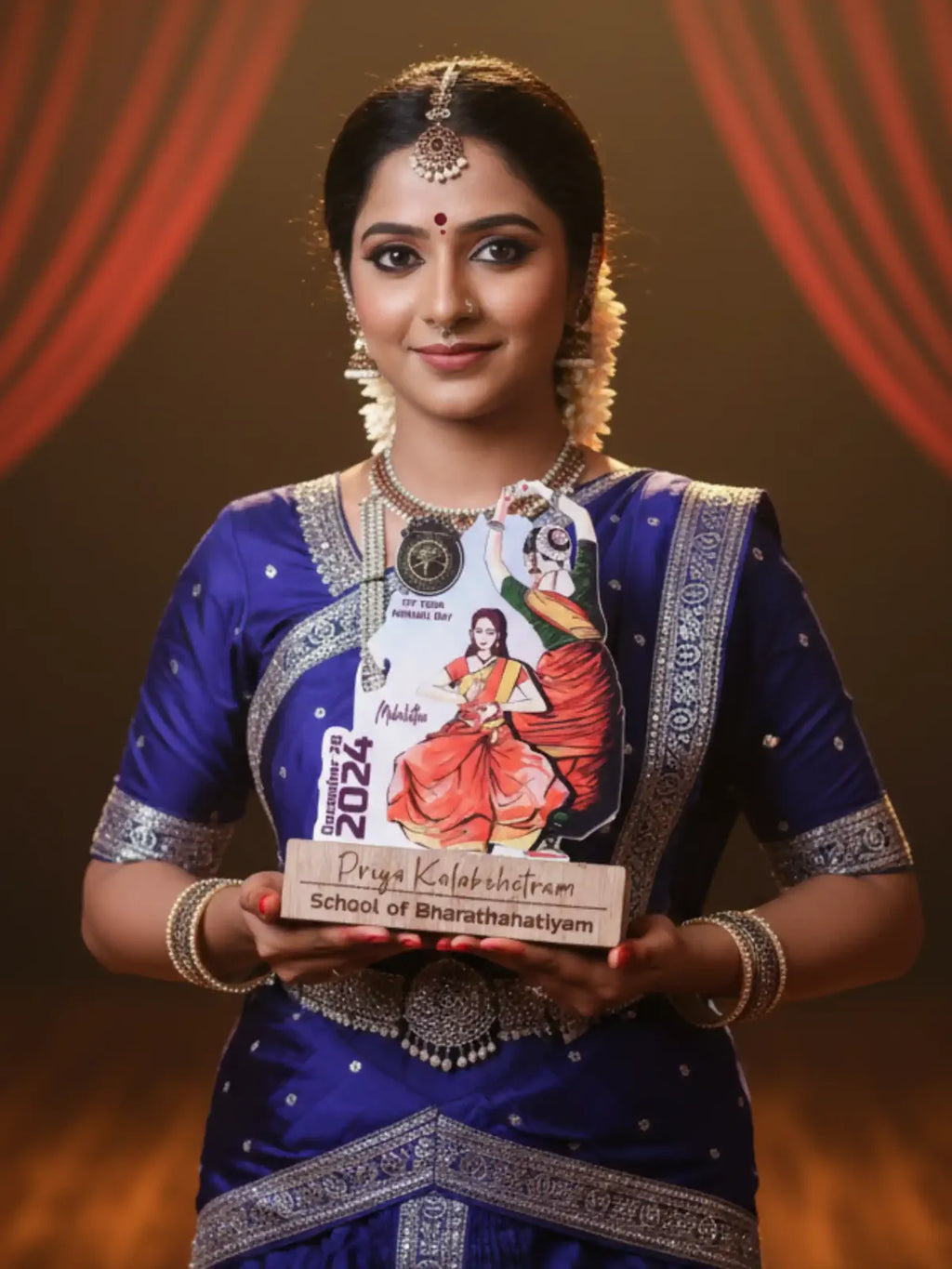 Woman in traditional attire holding a calendar with a Bharatanatyam dancer on a dark background