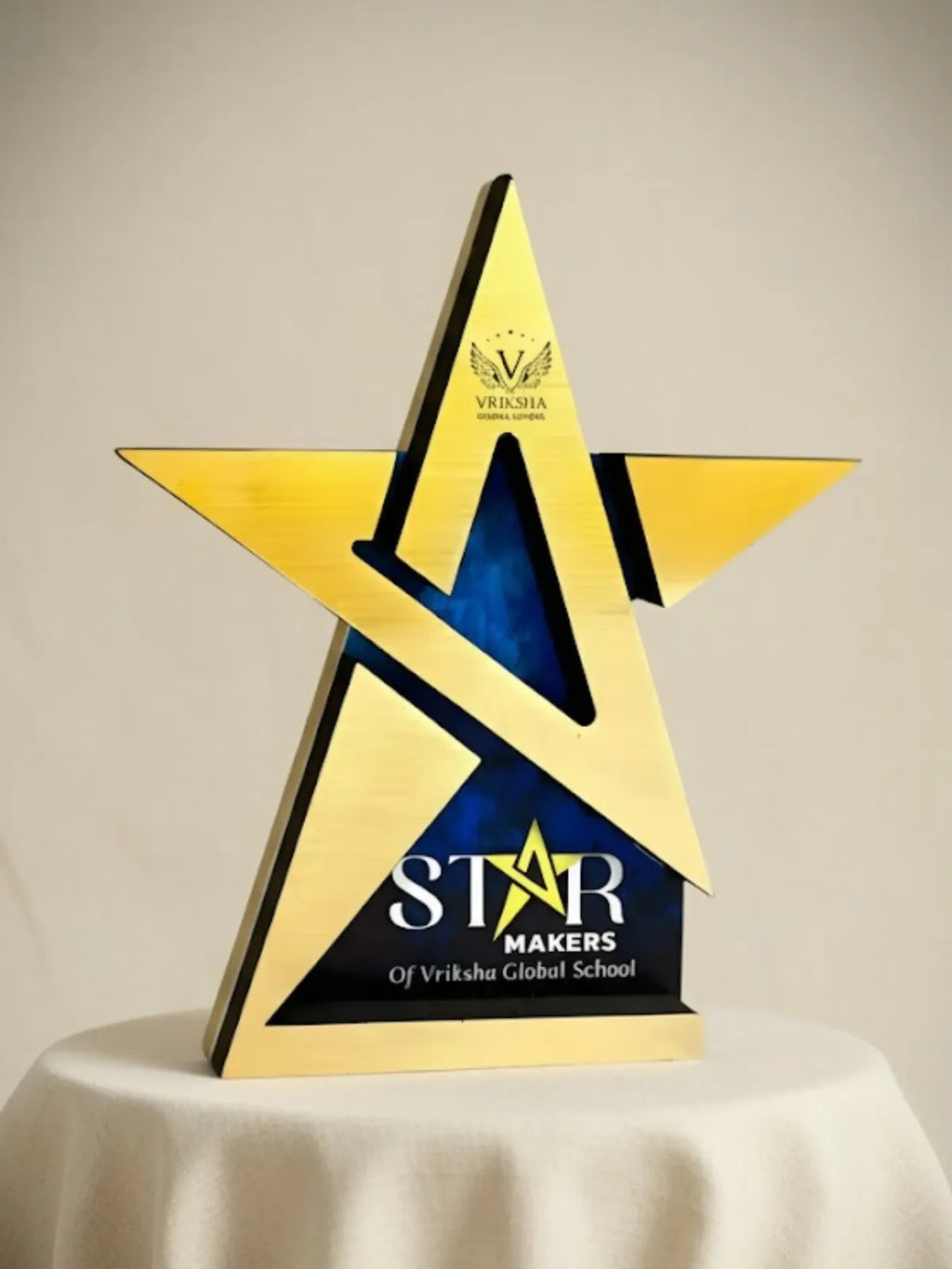 Gold and blue star-shaped award with 'STAR MAKERS' text on a beige background