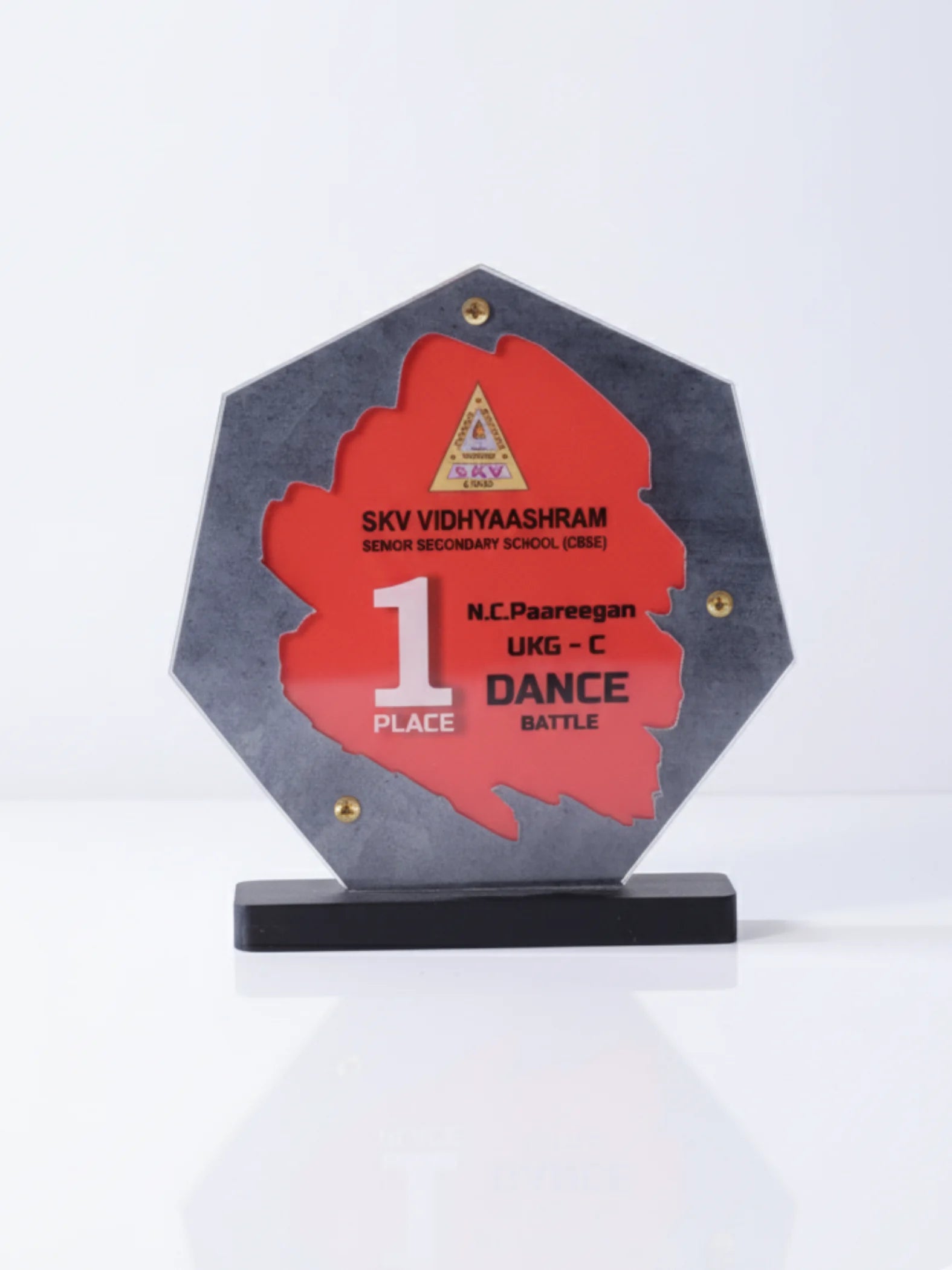 Hexagonal award with red center and gray base on a white background