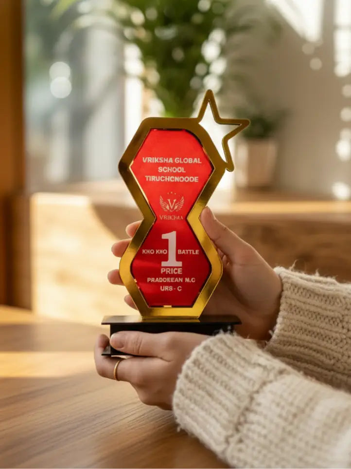 Person holding a red and gold award with 'Viksha Global School' on a blurred indoor background