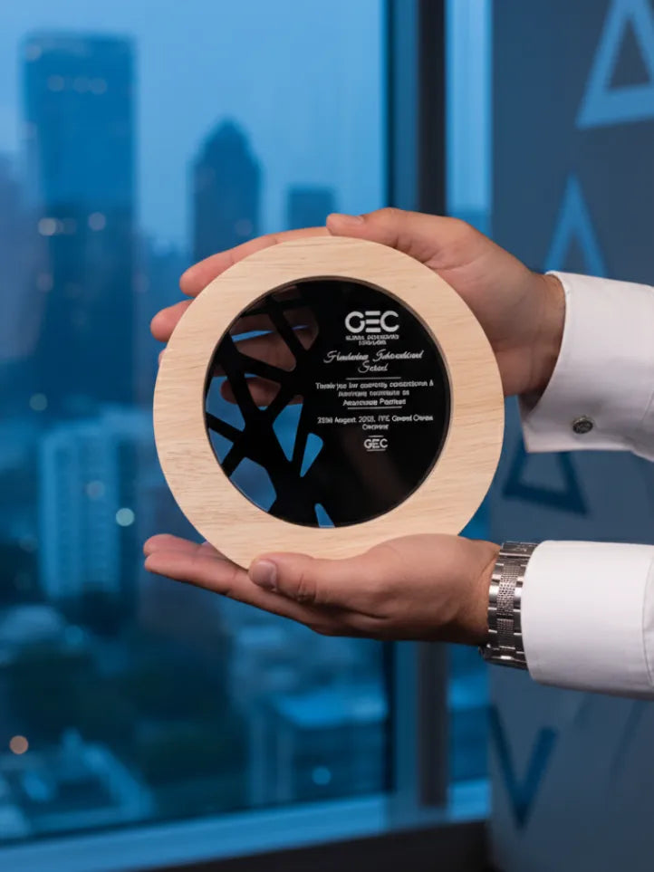 Person holding a wooden award with 'GEC' branding against a blurred cityscape background