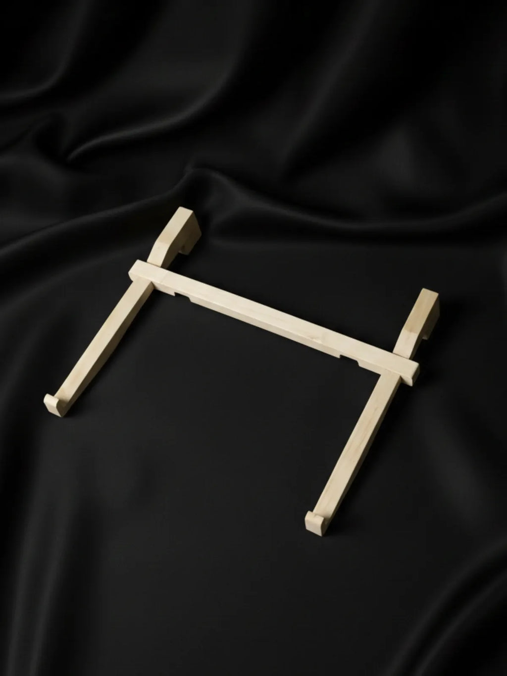 Wooden cross on a black fabric background