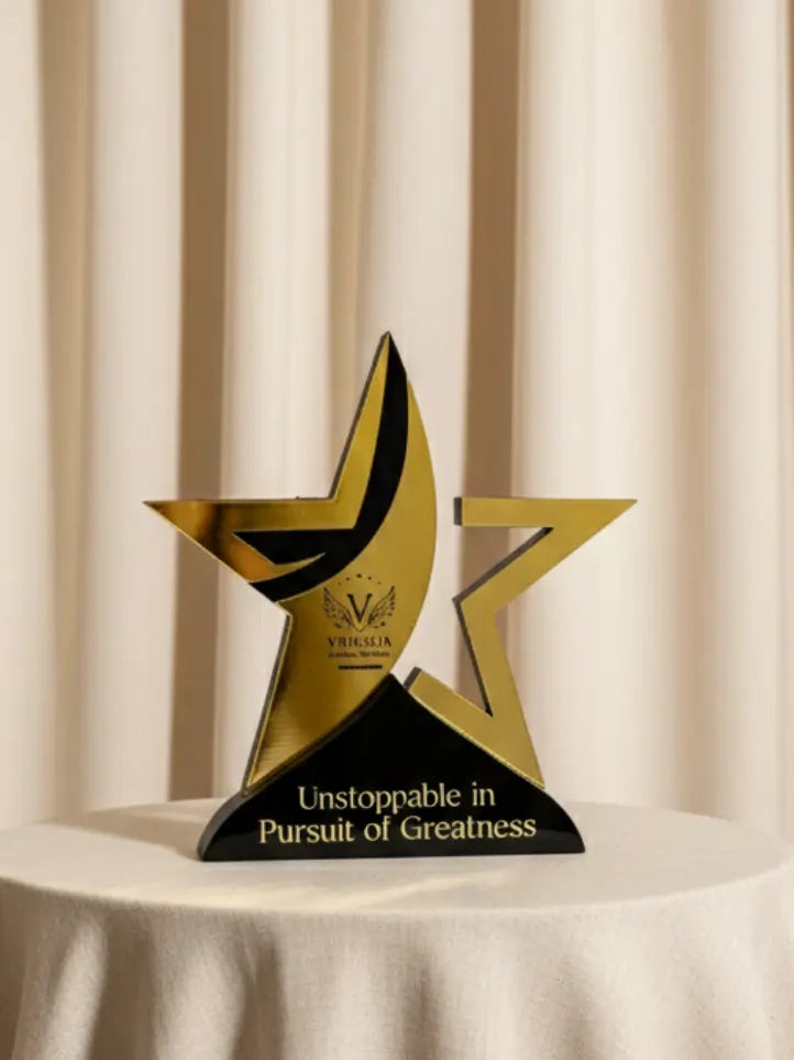 Gold and black star-shaped award on a white surface with a beige curtain background