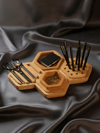 Wooden organizer with various items on a dark fabric background