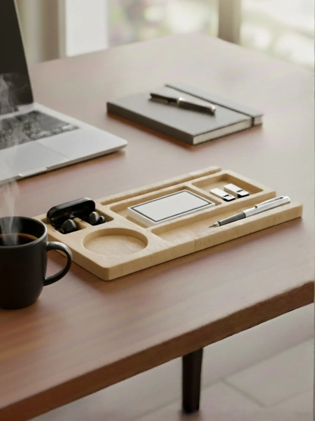 Desk setup with a wooden tray holding office supplies, a laptop, and a coffee cup.