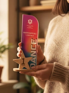 Person holding a colorful award with 'Dance' branding indoors