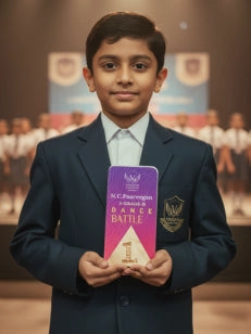 Young boy in a school uniform holding a book with a blurred school setting in the background