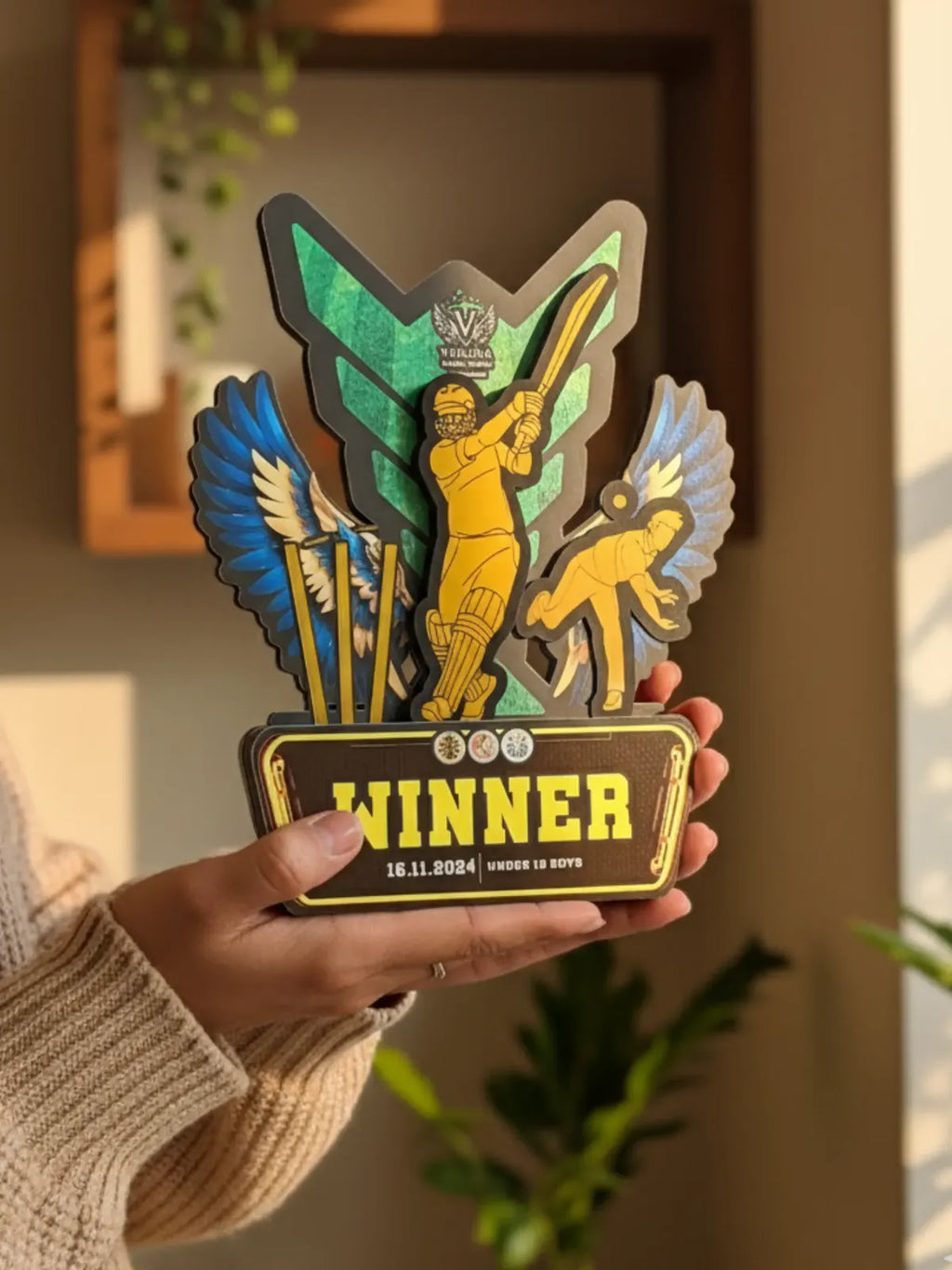 Hand holding a decorative award with 'Winner' text and colorful design.