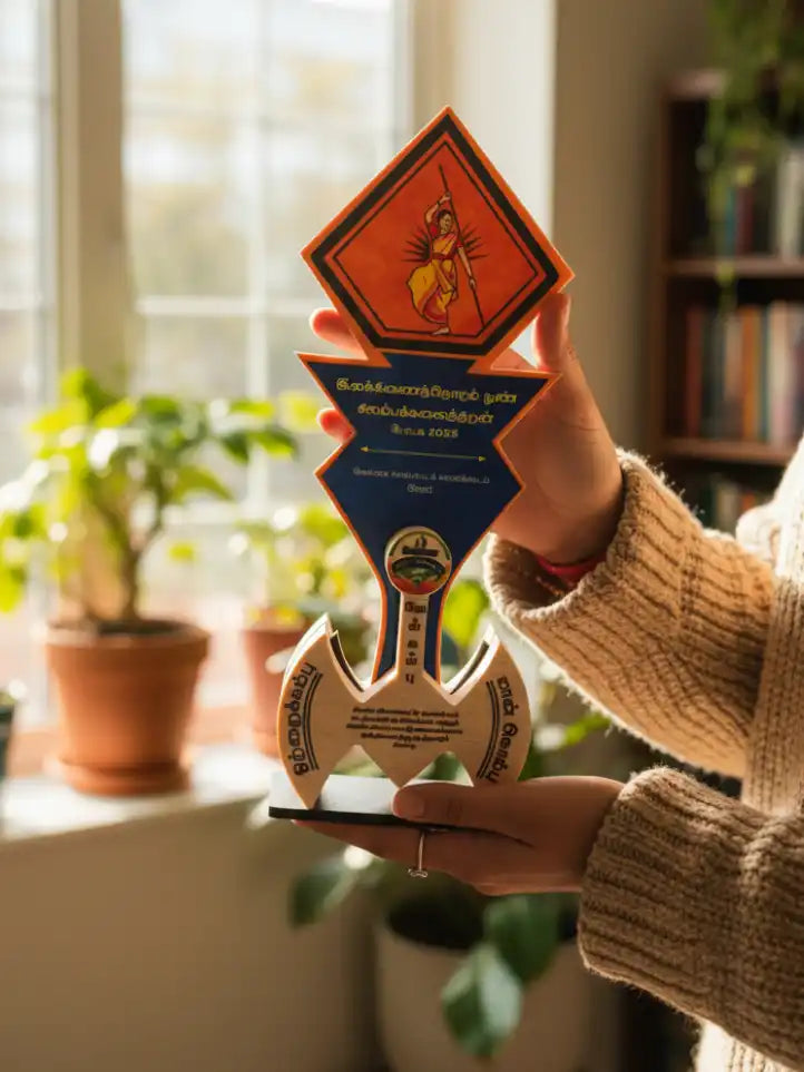 Person holding a decorative award with intricate designs indoors.