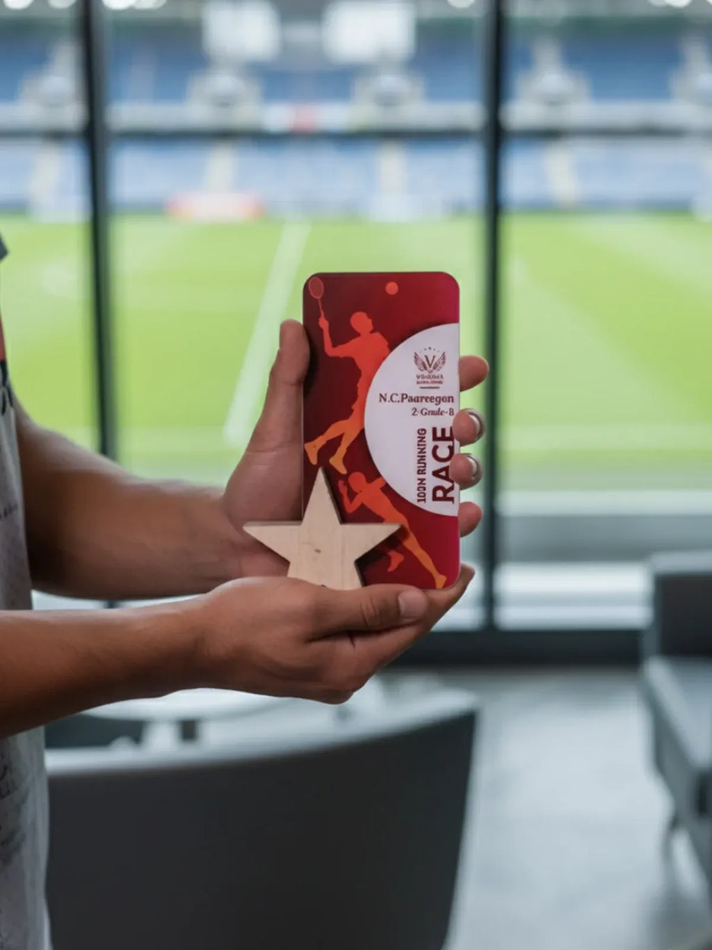 Person holding a red phone case with a star design in front of a blurred indoor background