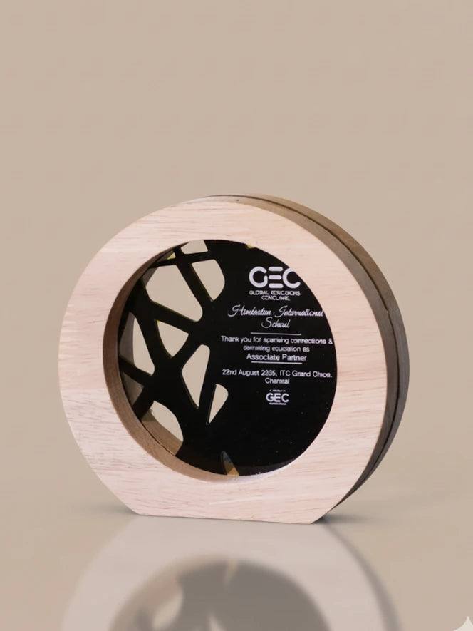 Decorative wooden disc with a black center on a beige background