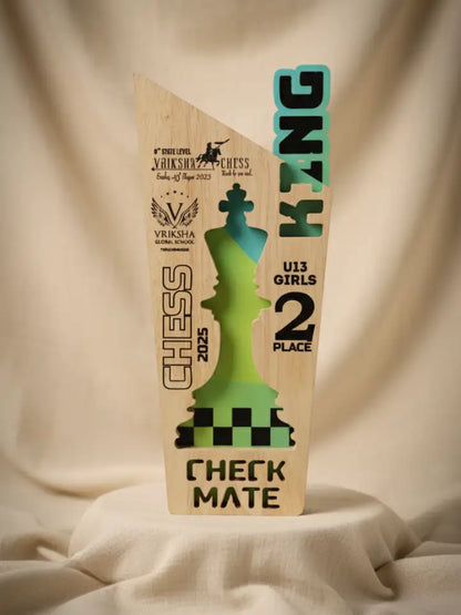Wooden chess-themed trophy with green and blue design on a beige fabric background
