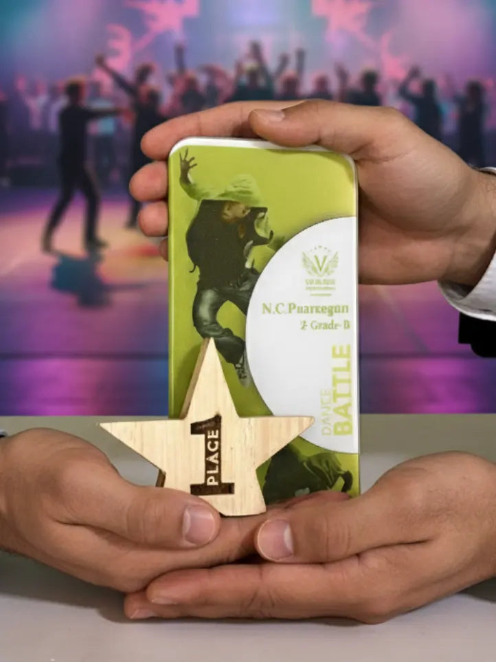 Person holding a green award box with a star-shaped wooden plaque in front of a blurred crowd background