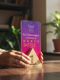 Hand holding a phone with a purple case displaying 'N.C. Pareegan Dance Battle' on a wooden surface.