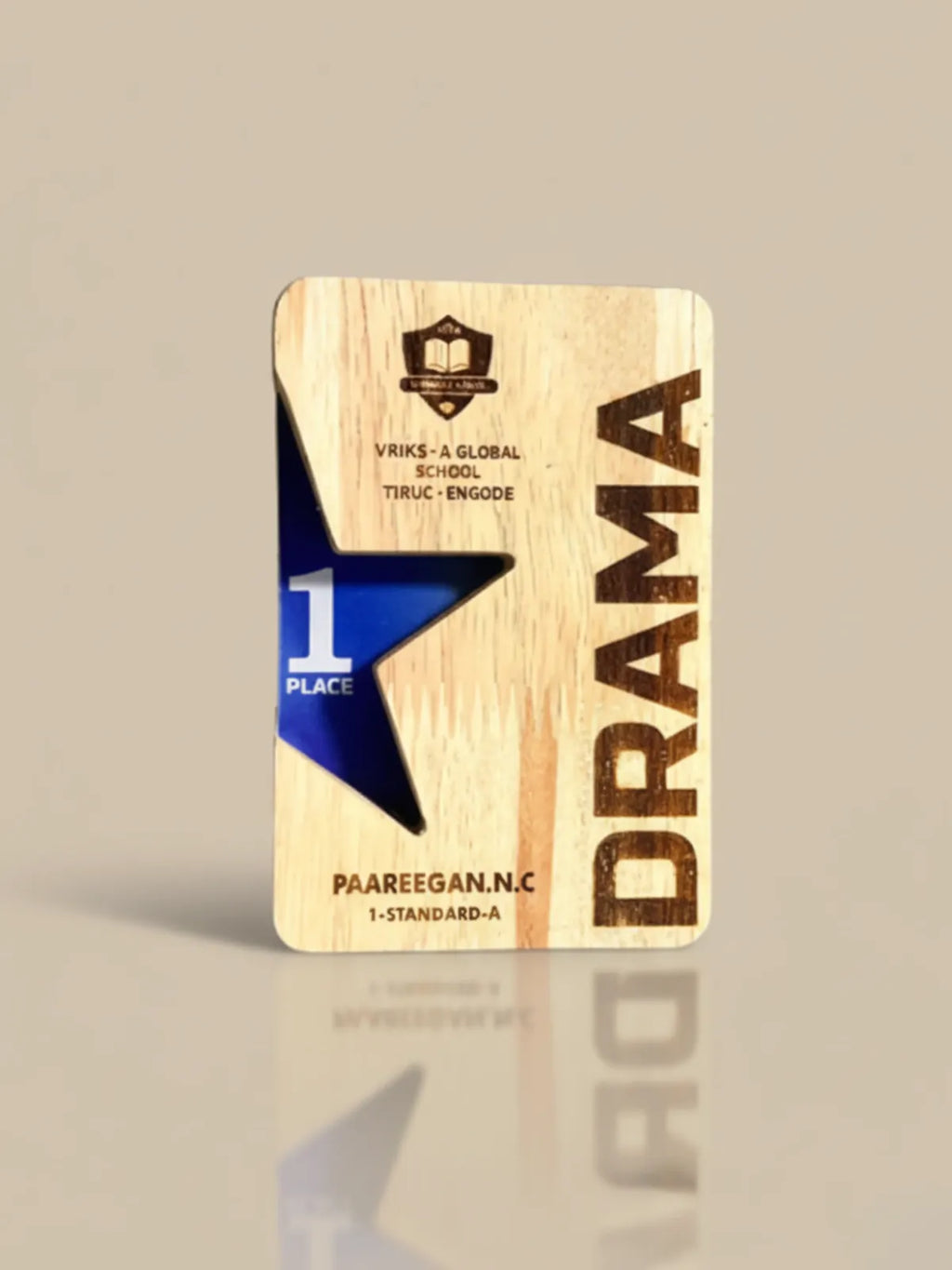 Wooden plaque with 'Drama' and '1st Place' text on a beige background