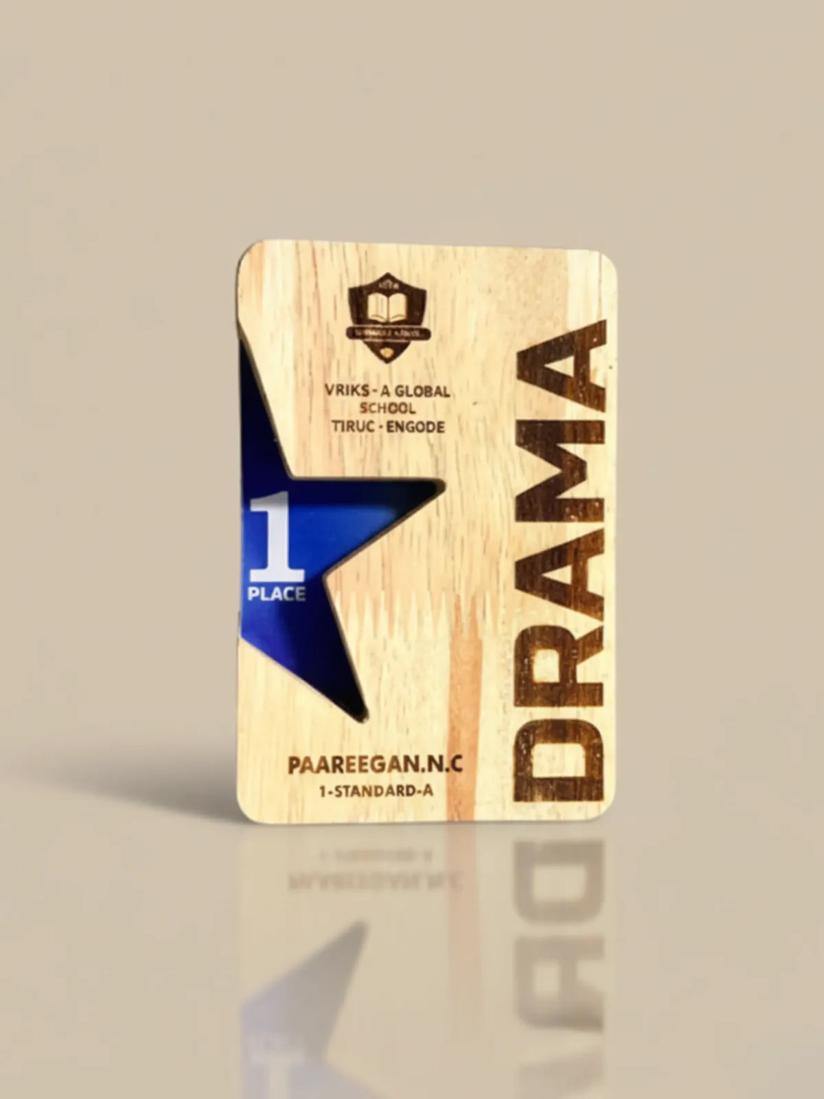 Wooden plaque with 'Drama' and '1st Place' text on a beige background