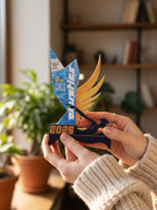 Person holding a blue and orange trophy with 'The Girls' and 'Sprinter' text in a home setting.