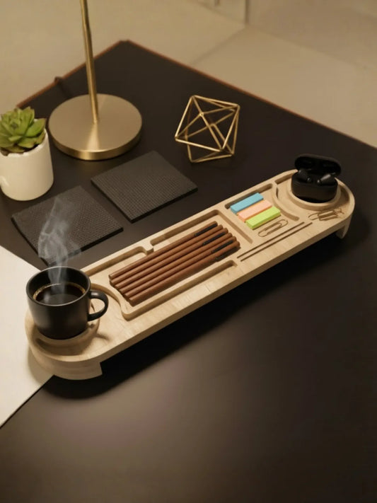 Desk setup with a wooden tray holding a cup of coffee, stationery items, and a small plant.