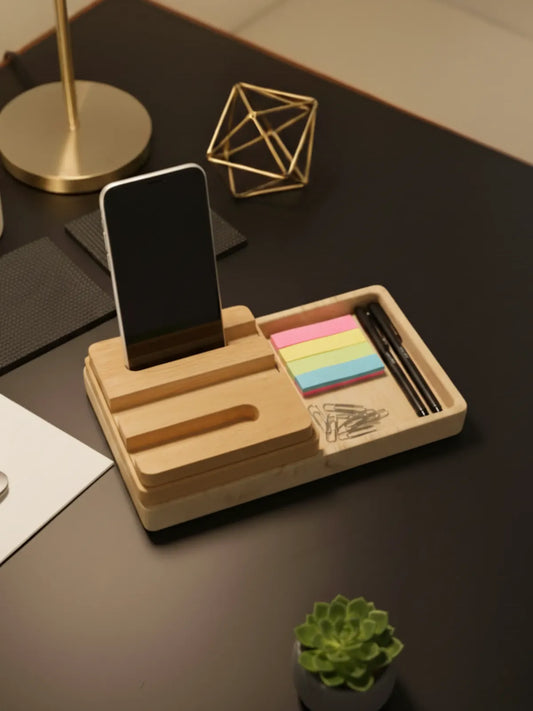 Wooden desk organizer with phone stand, sticky notes, and pens on a dark surface.