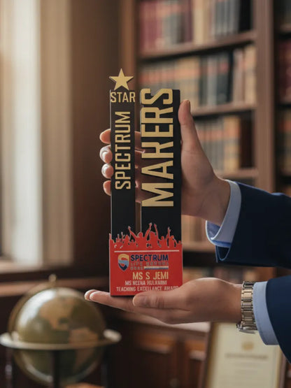 Hand holding a 'Spectrum Makers' product box in front of a bookshelf