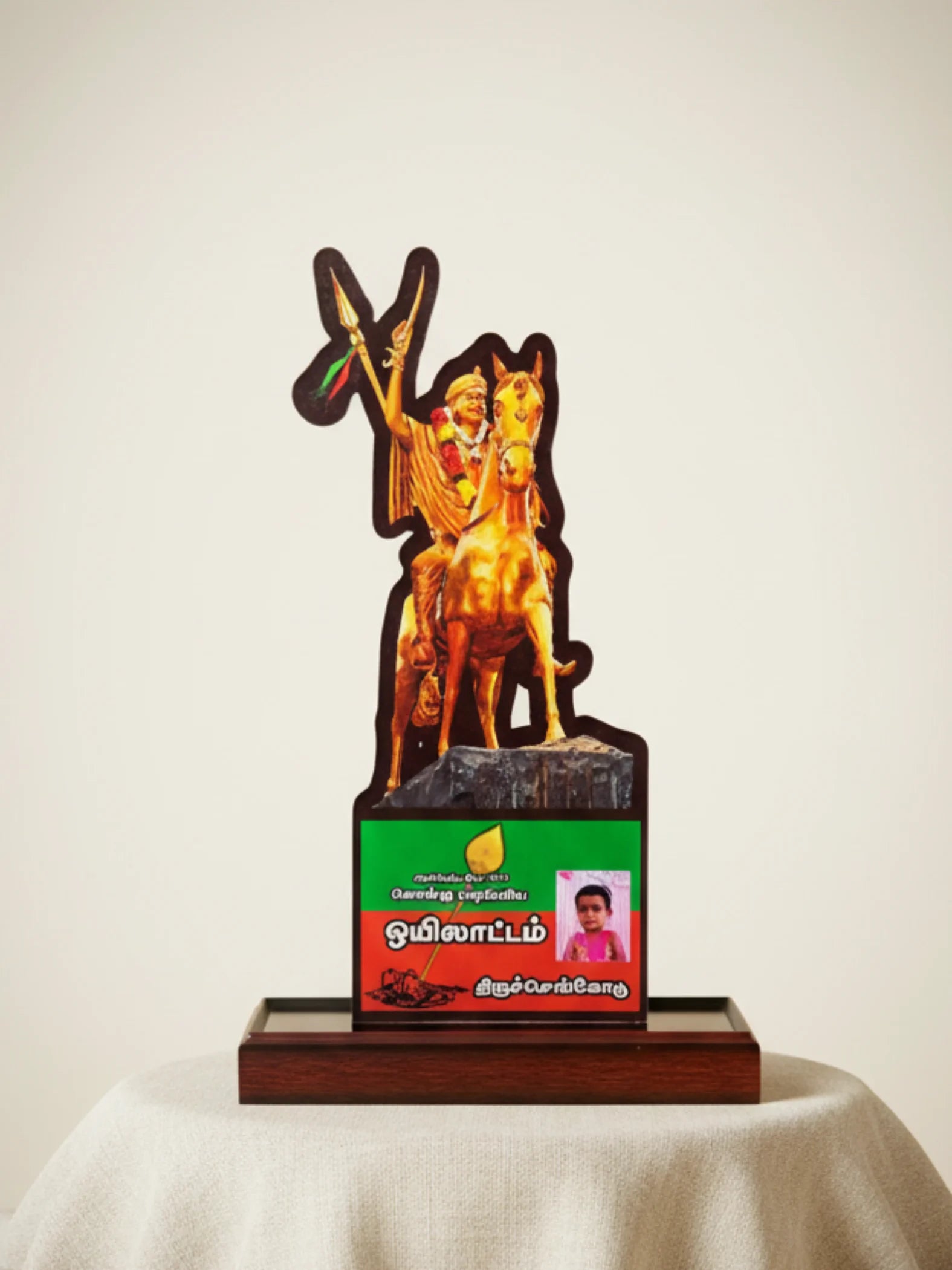 Decorative item with a figure on a horse and a green and red base on a white surface.