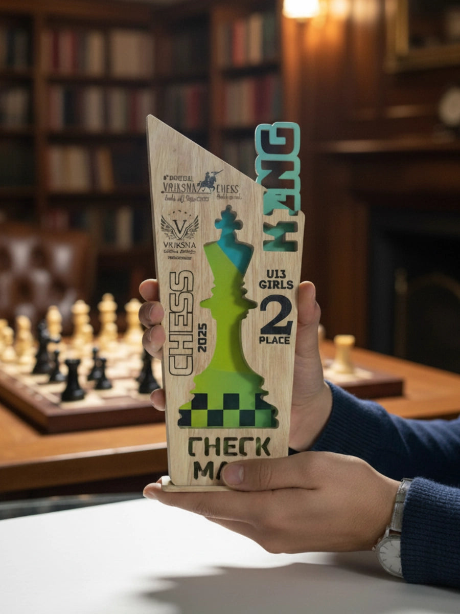 Wooden chess-themed trophy held in a hand with a blurred chessboard and books in the background