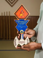 Person holding a decorative award with intricate designs and text.