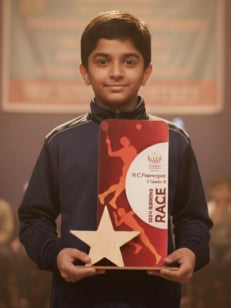 Young boy holding a red and gold award with a star on it.