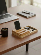 Wooden desk organizer with phone, pen, and other items on a desk with a laptop and coffee cup.