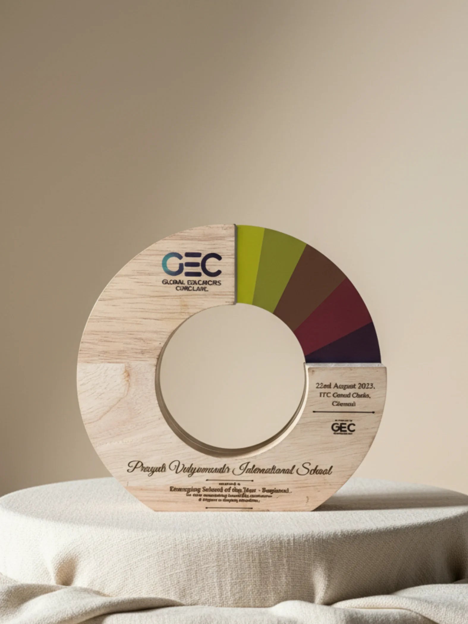 Wooden award with GEC logo and color wheel on a beige background