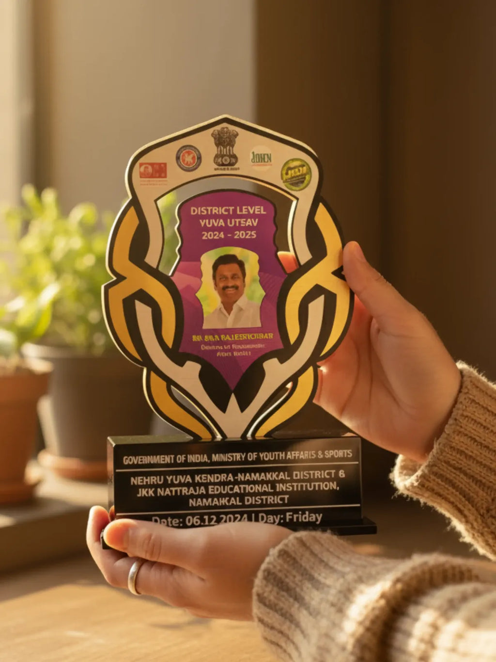 Person holding a district-level award with a blurred background