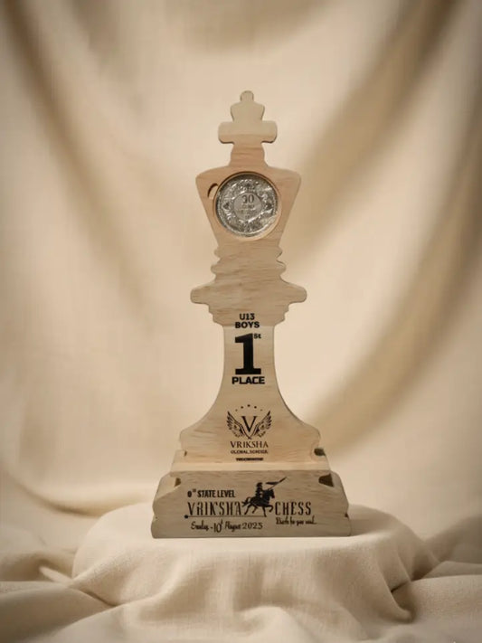 Wooden chess piece trophy with engraved text on a beige fabric background