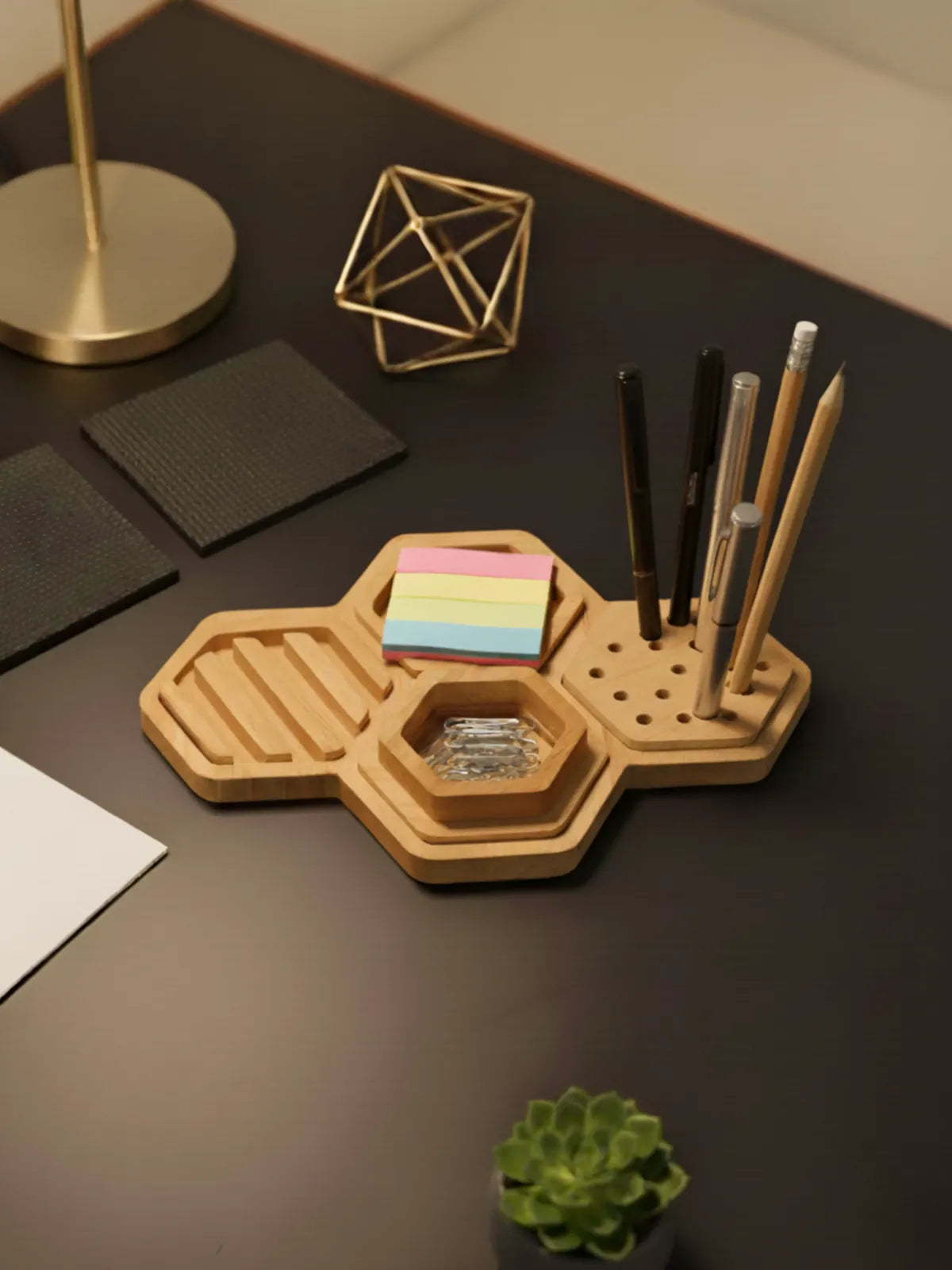 Wooden desk organizer with stationery items on a dark surface